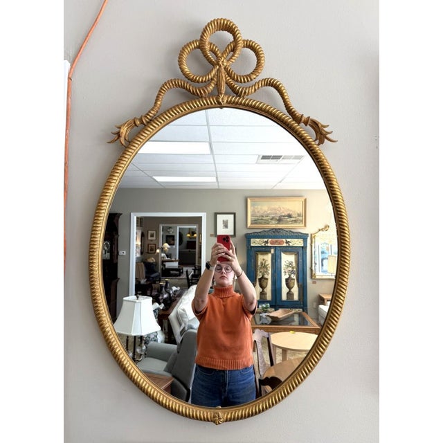 This Vintage Carvers' Guild Rope & Tassel Bow Oval Wall Mirror features an elegant oval form framed in richly gilded rope...