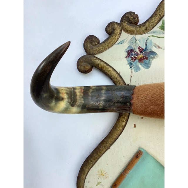 Late 1800s steer horn plaque with hand painted flowers and carved gold border with blue leather pocket. Features polished...