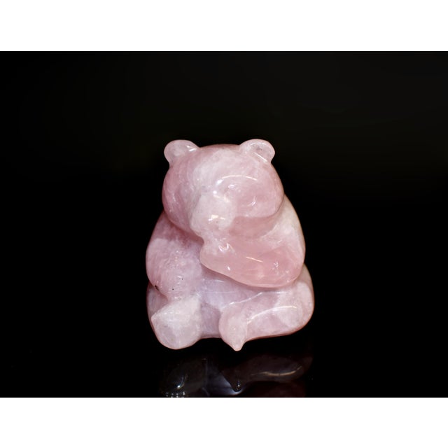 A charming hand-carved figure of a seated bear, sculpted from natural rose quartz of soft, translucent blush tone. With...