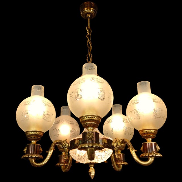 A beautiful French vintage 5-arm chandelier crafted from solid brass, featuring 15 detailed lion heads decorating the...