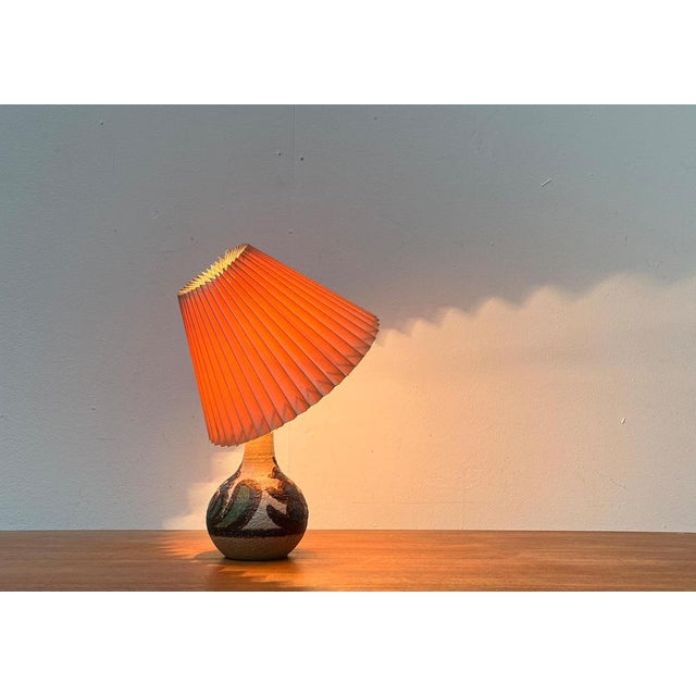 Ceramic table lamp from the Danish manufacturer Søholm from the 1960s. The conical pleated umbrella sits directly on the...