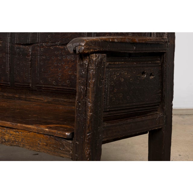 An impressive 18th-century Spanish rustic oak bench distinguished by its substantial construction, architectural...