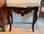 A walnut console of serpentine form, the shaped gray and fawn veined marble top above a deeply carved and pierced apron of...