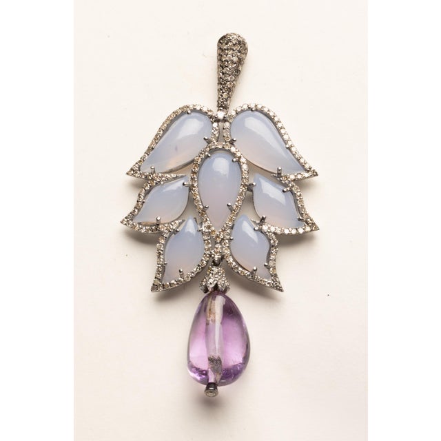 A stunning pair of chandelier earrings with cluster of 7 tear-drop shaped chalcedony stones per earring bordered with...