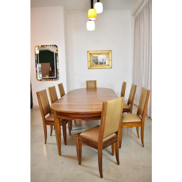 An exceptional André Sornay dining ensemble from the 1930s: an extendable walnut table paired with eight matching chairs,...