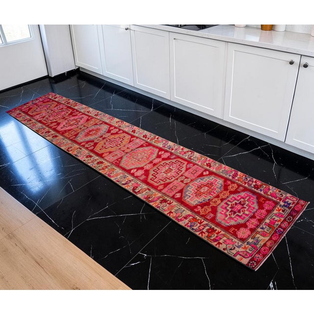 Woven in the 1960s in Southeastern Anatolia, this striking hand-knotted runner rug brings vibrant energy and historic...