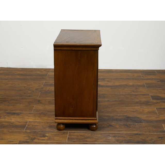 An Italian oak small cabinet from the early 19th century, with single door and geometric carved motif. Created in Italy...