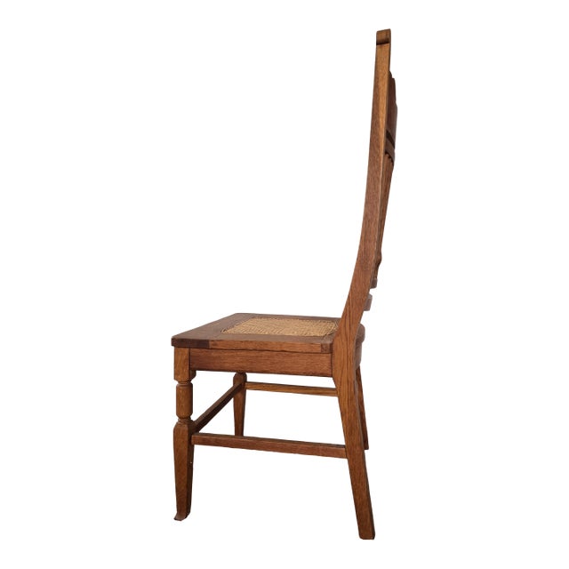 Handcrafted antique oak slat-back chair featuring a finely shaped crest rail, turned vertical spindles, and a traditional...