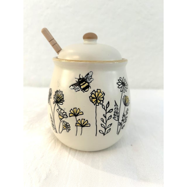 Charming ceramic lidded honey pot with bumble bee and floral motif around perimeter. Wood dowl stirrer included. Excellent...