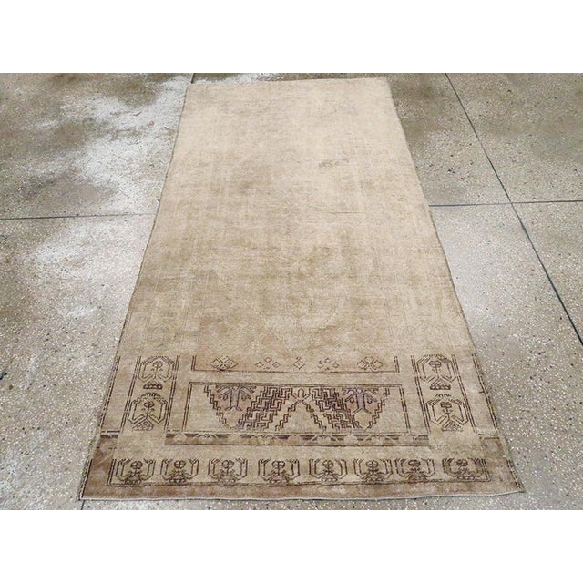 A vintage Turkish Oushak accent rug. This long Turkish scatter may have been woven closer to central Anatolia. The colors...