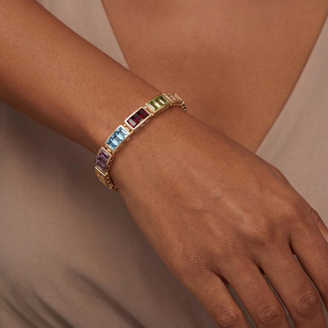 A vintage 14k gold heavy link bracelet featuring emerald-cut blue topaz, amethyst, garnet, citrine and peridot gemstones....