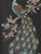 A 1960s acrylic painting of a turquoise peacock with a pink flowering branch on a black ground. Set in a honey toned wood...