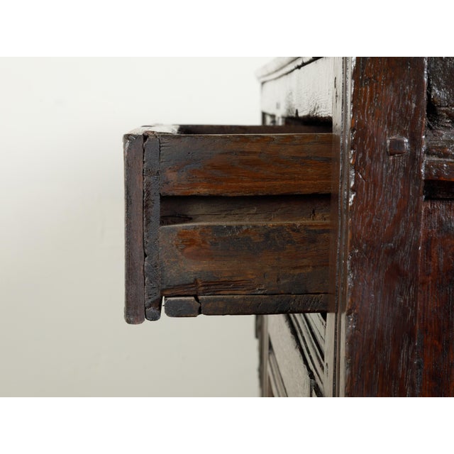 An English wooden court cupboard from the early 19th century, with diamond motifs, doors and drawers. Created in England...