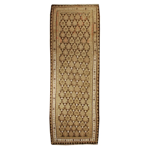 An early 20th century Persian Qazvin Kilim runner with all-over tree-of-life pattern on a natural, un-dyed background,...