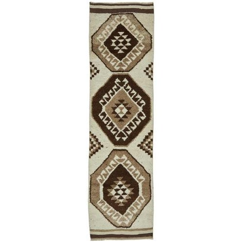 This exquisite runner rug is a rare example of tribal craftsmanship, hand-knotted by the women of the Herki tribe during...