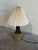 This charming ceramic table lamp features a textured brown base and pleated shade. The warm silhouette brings cozy...