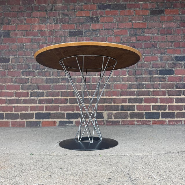 This is an iconic Noguchi for Knoll cyclone dining table with a 36” white laminate top. The black cast iron base contrasts...