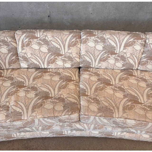 Beautiful vintage curved sofa featuring a graceful serpentine silhouette and elegant proportions. The sofa is upholstered...