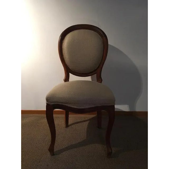 This is a set composed by 4 chairs in walnut and upholstered in linen fabric, totally made in Italy in the 1990' years....