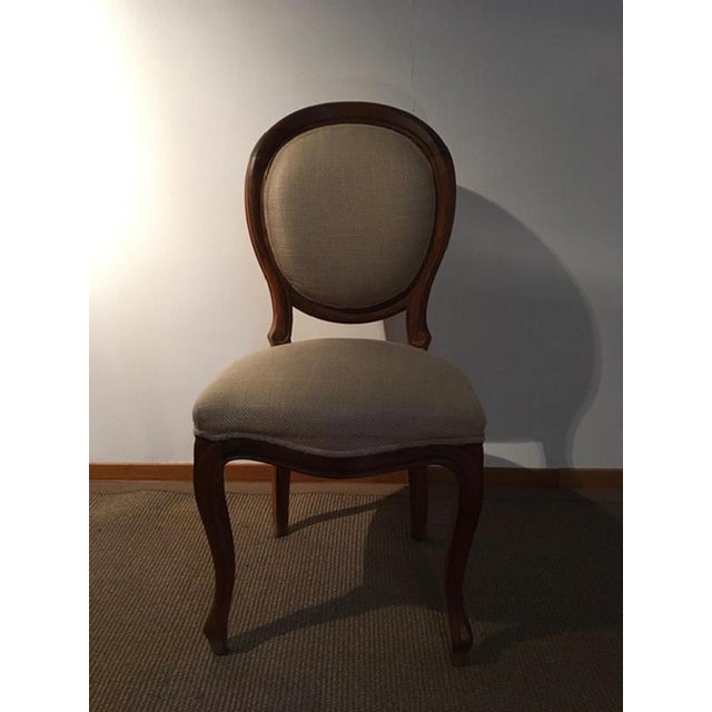 This is a set composed by 4 chairs in walnut and upholstered in linen fabric, totally made in Italy in the 1990' years....