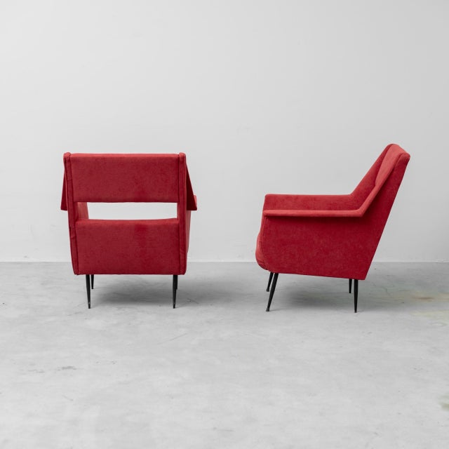 Pair of Gigi Radice armchairs made in the 1960s. Red fabric upholstery. Metal legs. Item as pictured. This piece is...