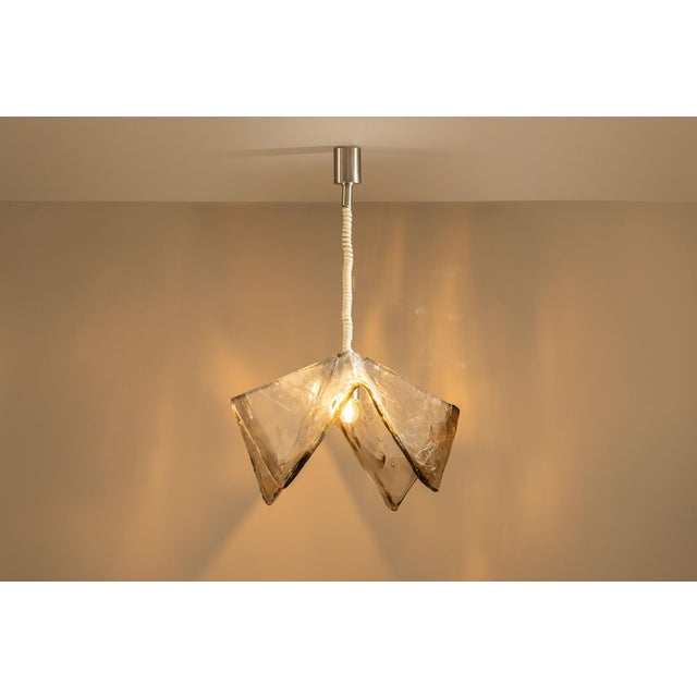 Light and glass meet here in a sculptural gesture that captures the spirit of murano in the 1970s. This pendant lamp,...