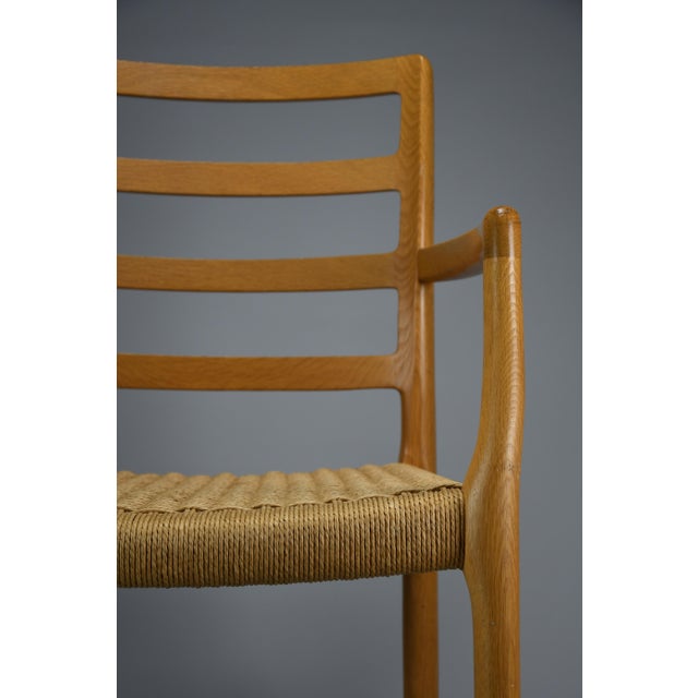 An elegant Model 68 armchair in solid oak with a hand-woven natural papercord seat, designed in 1981 by Niels Otto Møller...