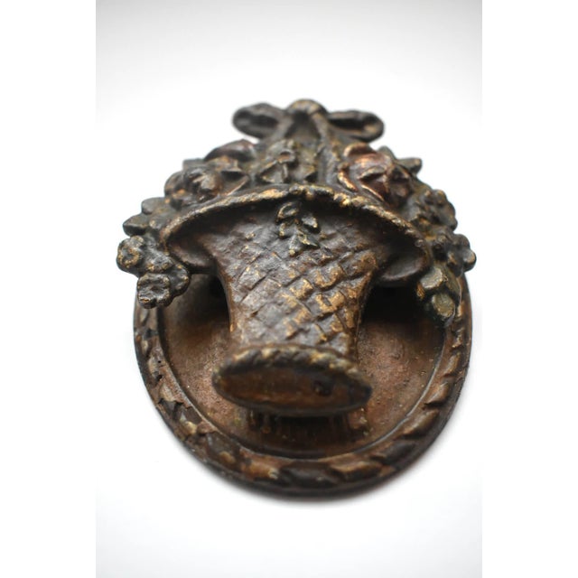 Oval Cast Iron Floral Door Knocker circa 1920. The Patina has aged, the original red and green colored flowers are faint...