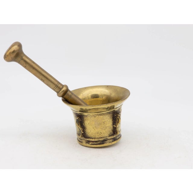 This early 20th-century mortar and pestle is made of brass with an honest patina. Both the mortar and pestle are...