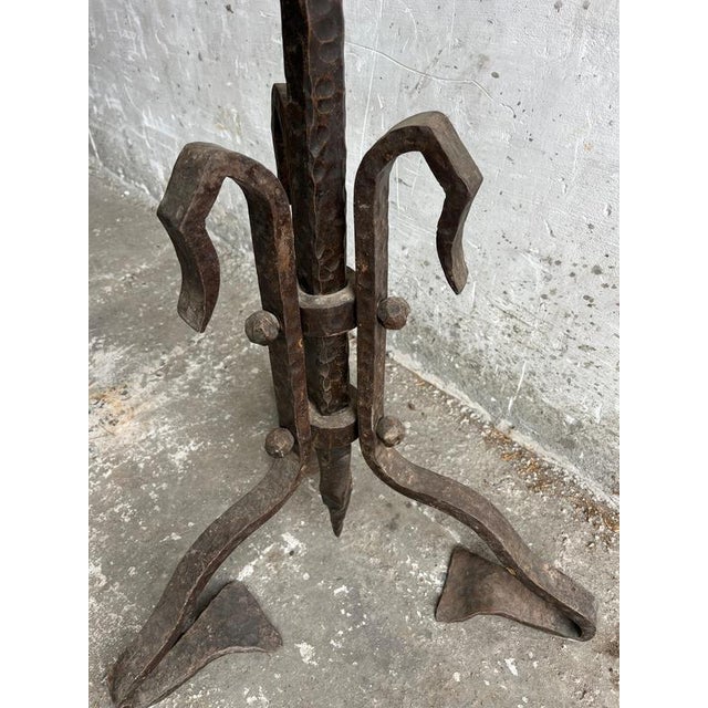 Brutalist wrought iron floor sculpture with a striking hand-forged hammered finish and architectural tripod base. The raw...
