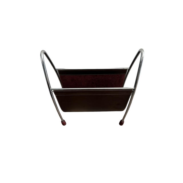 Sleek, modern leather magazine rack with chrome frame and wooden feet. Top stitching on leather. c. 1990s Dimensions: 16"w...