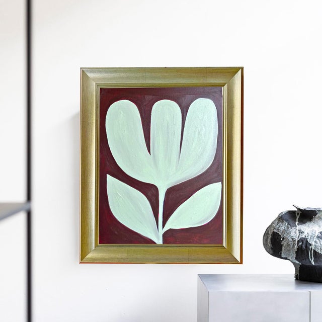 Finished in a brushed gold frame that beautifully complements the warm burgundy background. Ready to hang as acquired....