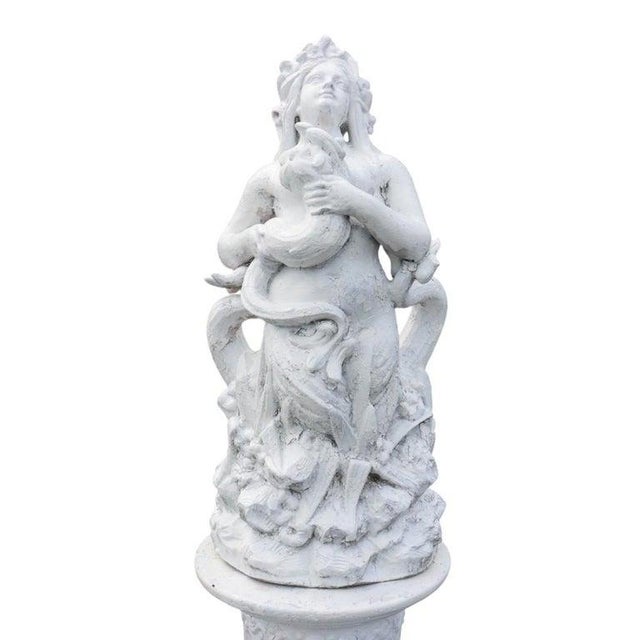 This is a pair of antique classical figural terra cotta sculptures, each presented on a fluted pedestal stand. The figures...