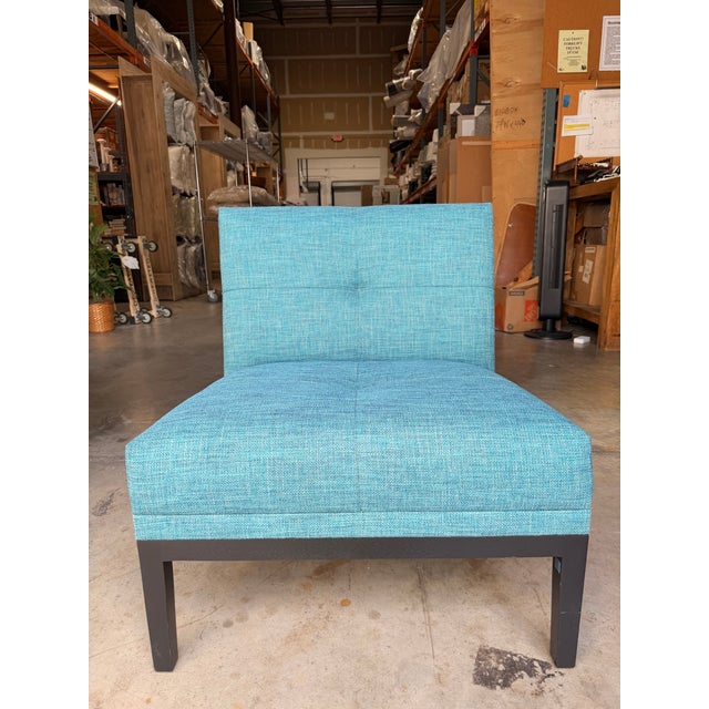 Contemporary accent lounge chair featuring clean architectural lines upholstered in a vibrant turquoise-blue textured...