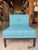 Contemporary accent lounge chair featuring clean architectural lines upholstered in a vibrant turquoise-blue textured...