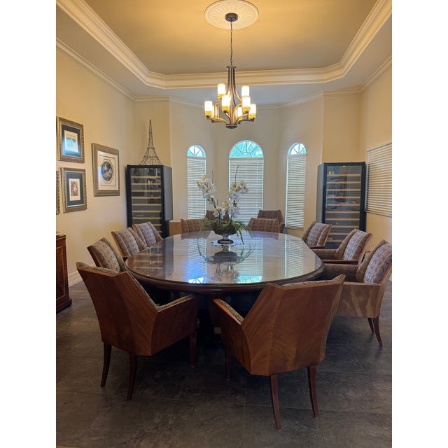 Twelve custom mahogany upholstered armchairs, this sophisticated set combines striking architectural design with timeless...