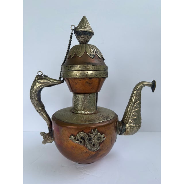 Vintage Tibetan-style copper and brass ceremonial ewer or teapot featuring elaborate hand-worked and applied ornamentation...