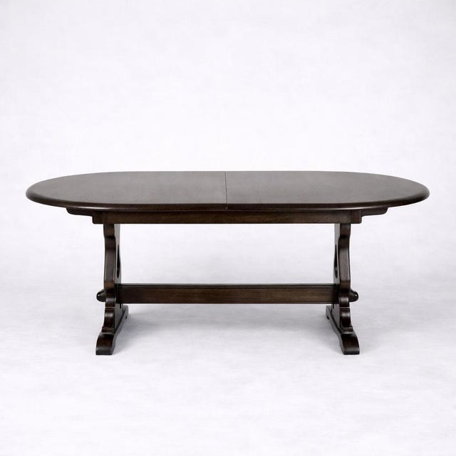 A beautifully crafted vintage Ercol elm oval extending dining table, showcasing the timeless craftsmanship and practical...