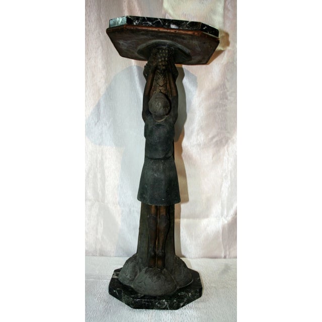 An exceptional French Art Deco pedestal side table dating to circa 1930, featuring a sculptural spelter base depicting two...