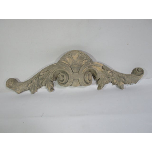 A vintage decorative architectural wall decor scroll. It is made of cement with a gray tone and has a wire on the back for...
