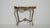 A richly styled console table inspired by Baroque design, featuring curved lines, decorative legs, and a naturally aged...
