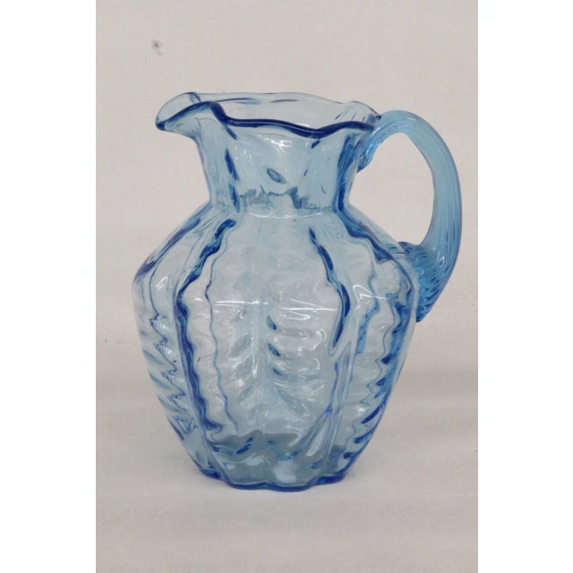This Small Pitcher is made of glass. This Pitcher is made of beautiful ice blue glass. This piece has classic Fenton style...