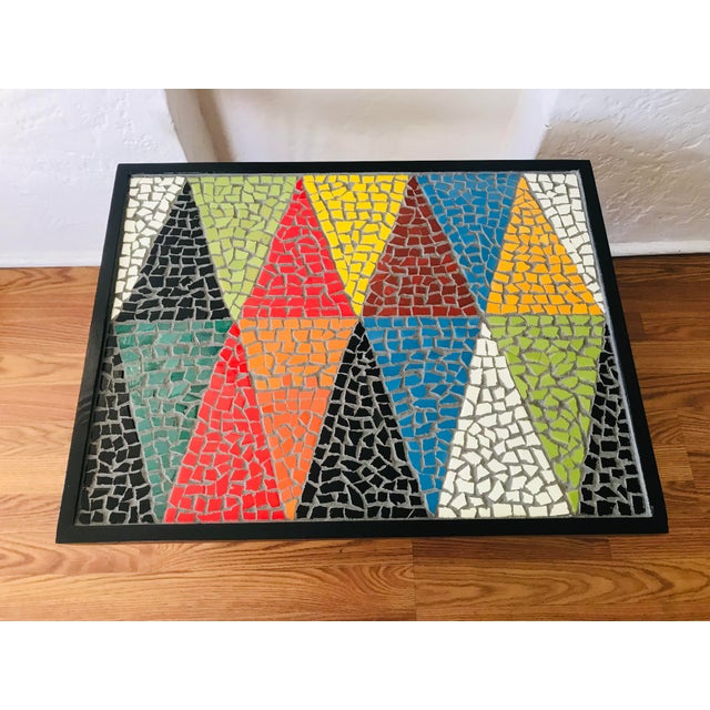 Custom Made coffee table features a colorful geometric shapes mosaic tile top. The surface is composed of triangular...