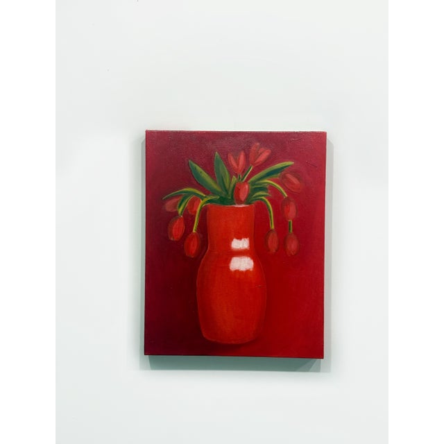 Original still life painting featuring a monochromatic red palette with a vibrant vase of tulip-like flowers against a...