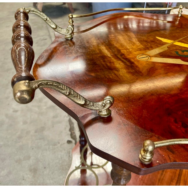 Striking mid-century Italian bar or serving cart featuring richly figured wood veneers, decorative marquetry and elegant...