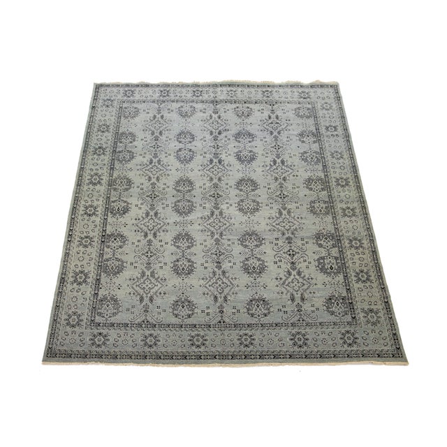 This Tabriz-style wool rug features a beautifully intricate floral design, elegantly showcased against a gray background...