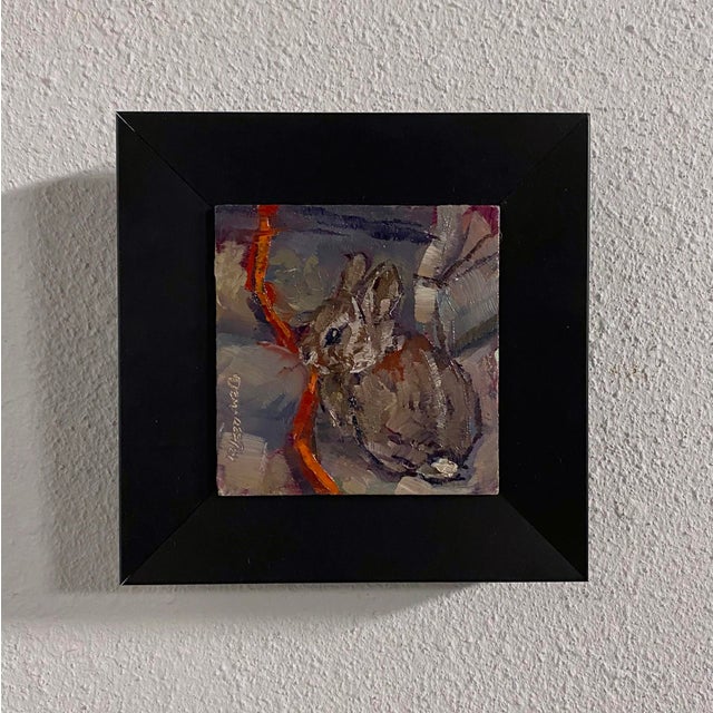 This intimate oil painting captures a serene moment of a bunny nestled among soft, muted colors. The brushwork is...