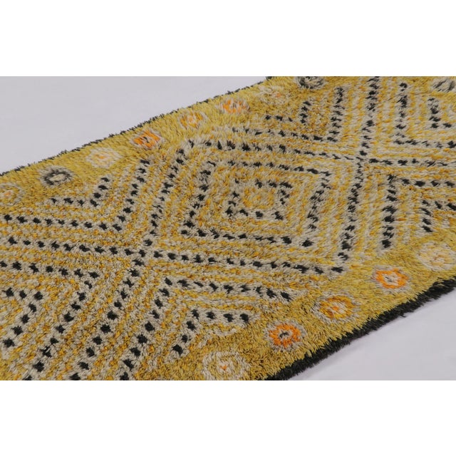 Hand-knotted in lush, high-pile wool in Sweden circa 1960-1970, this 4x7 vintage Swedish Rya rug is a bold new addition to...