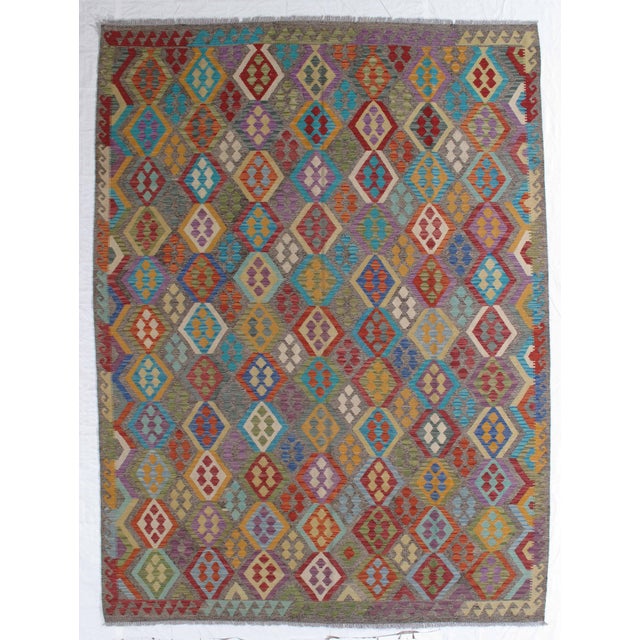 Handwoven Afghan kilim flatweave rug featuring an allover geometric diamond pattern in vibrant, multicolored tones. Woven...