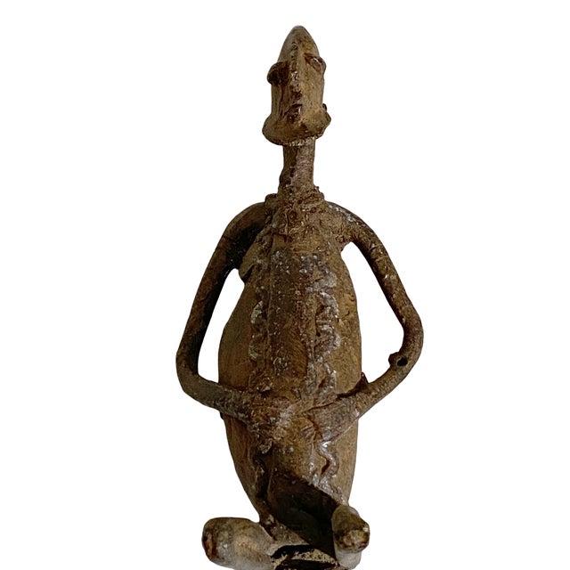 Superb dogon bronze Mali. This bronze is cast over the stone into the form of a seating male holding his belly with...